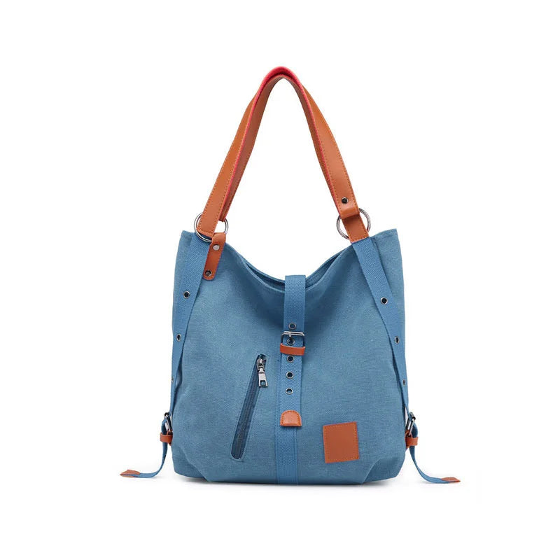 Women’s soft canvas backpack in blue with zipper closure, top handle, and shoulder straps, featuring external pockets and a casual everyday design.