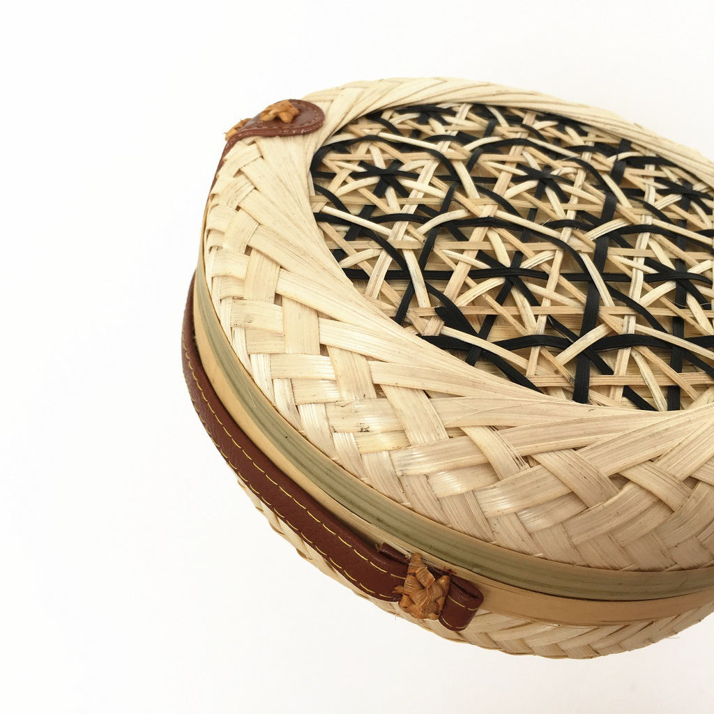 Woven basket with decorative lid on a white background