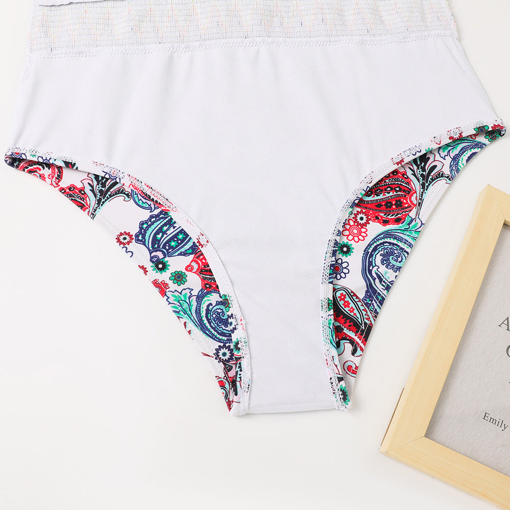 White garment with colorful paisley trim on a white background