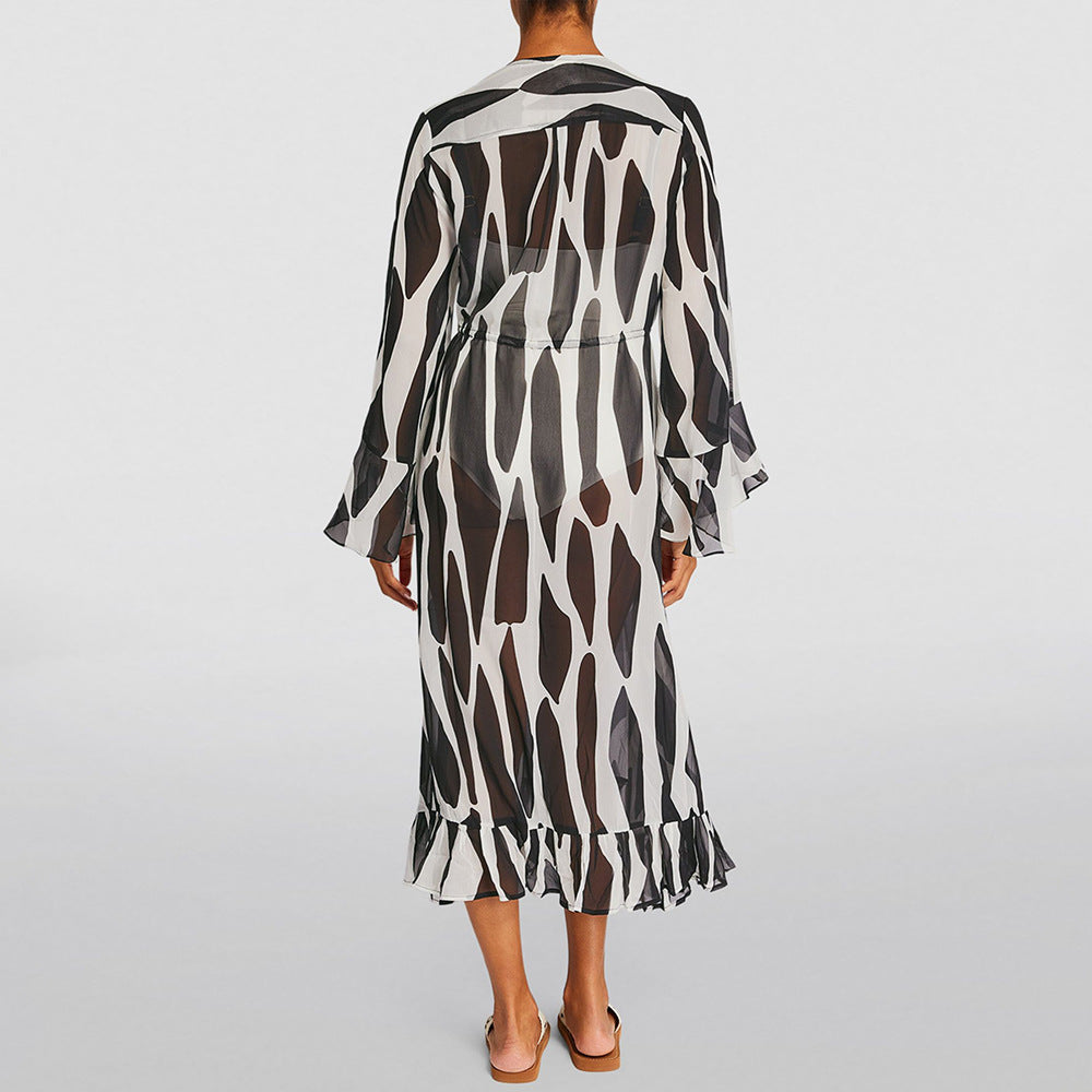 Person wearing a black and white patterned dress on a light gray background