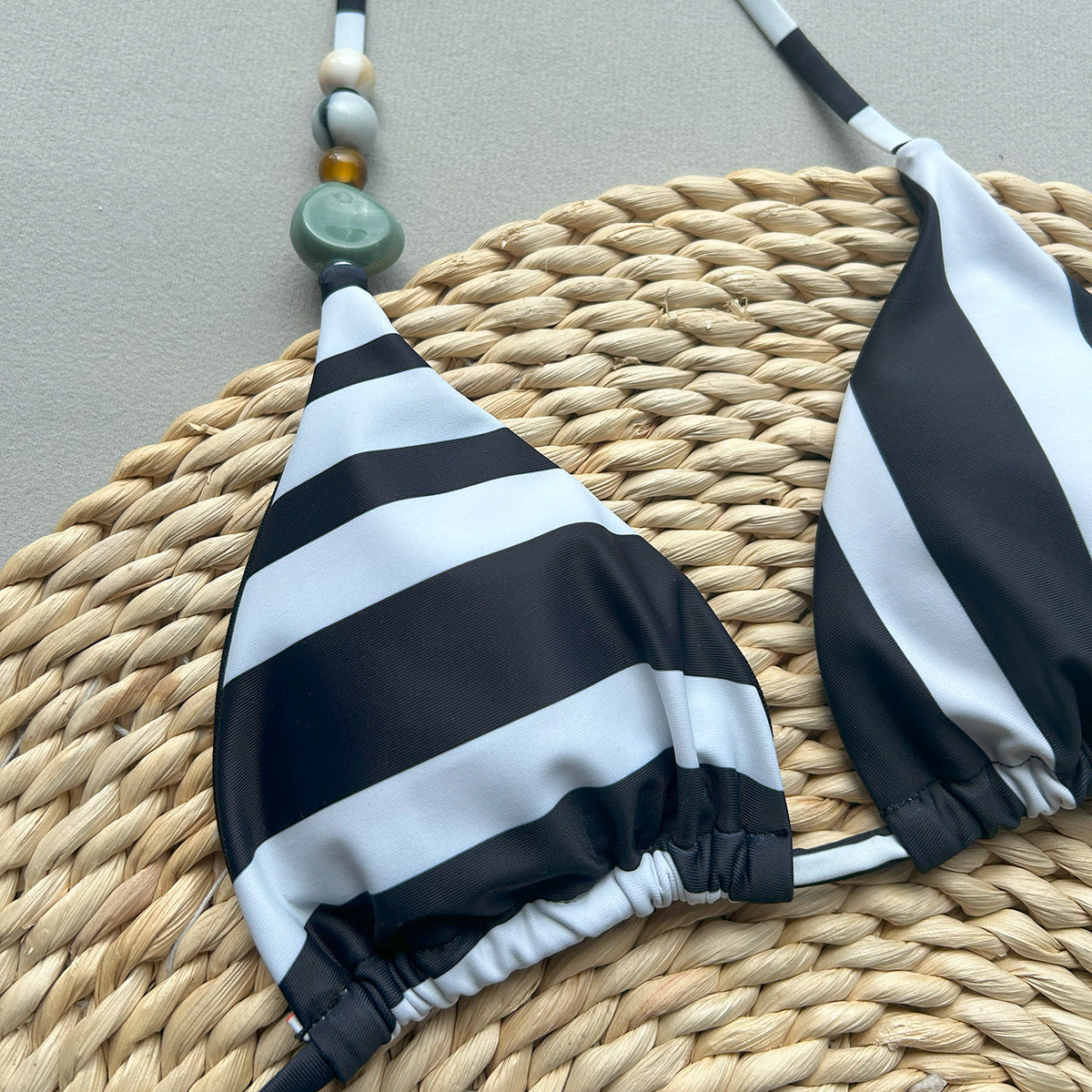 Black and white striped bikini set on a woven mat