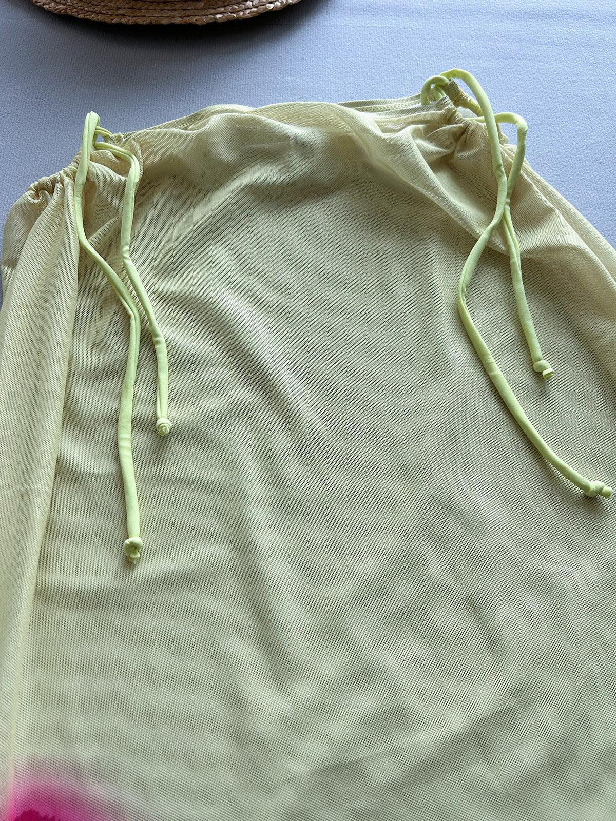 Light green drawstring bag on a light blue surface