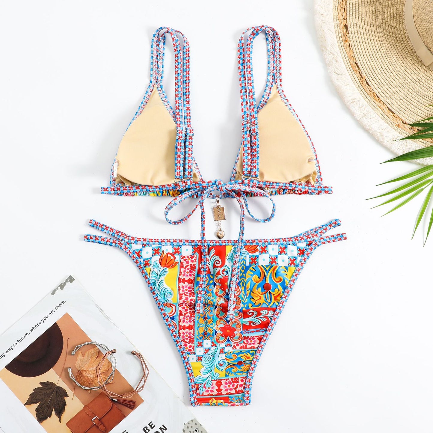 Colorful bikini set with a straw hat and magazine on a white background