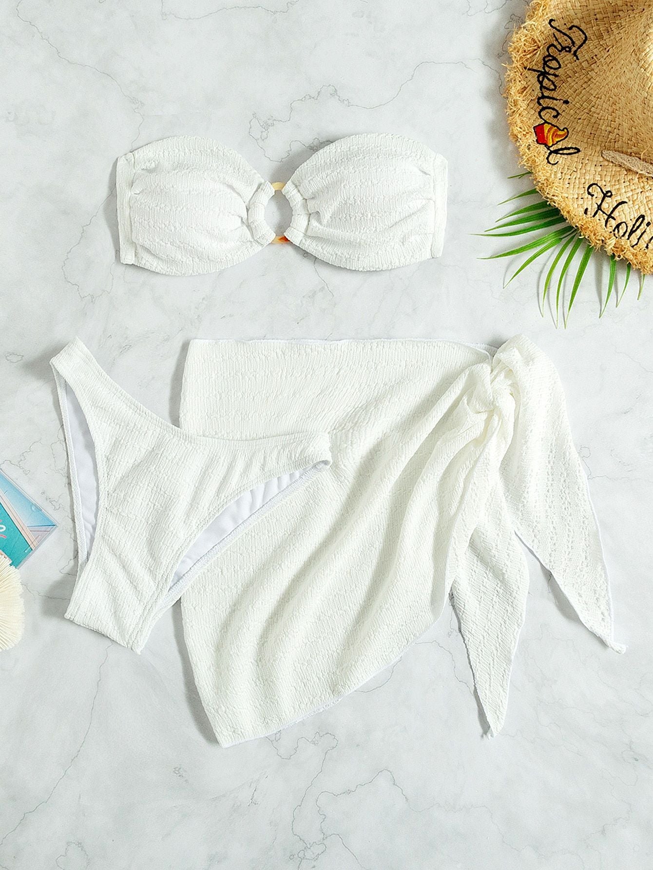 White bikini set with matching headband on a light gray surface.