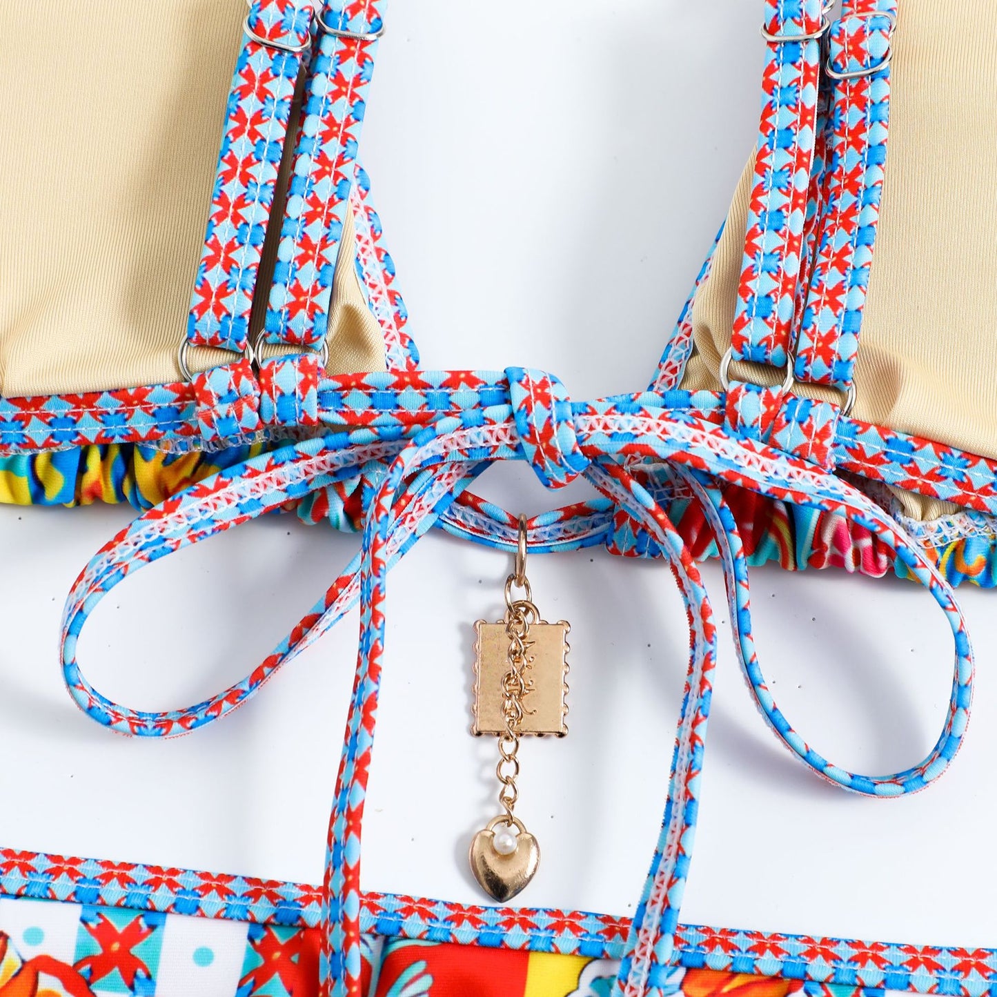 Colorful dog harness with floral pattern and decorative charm on a white background