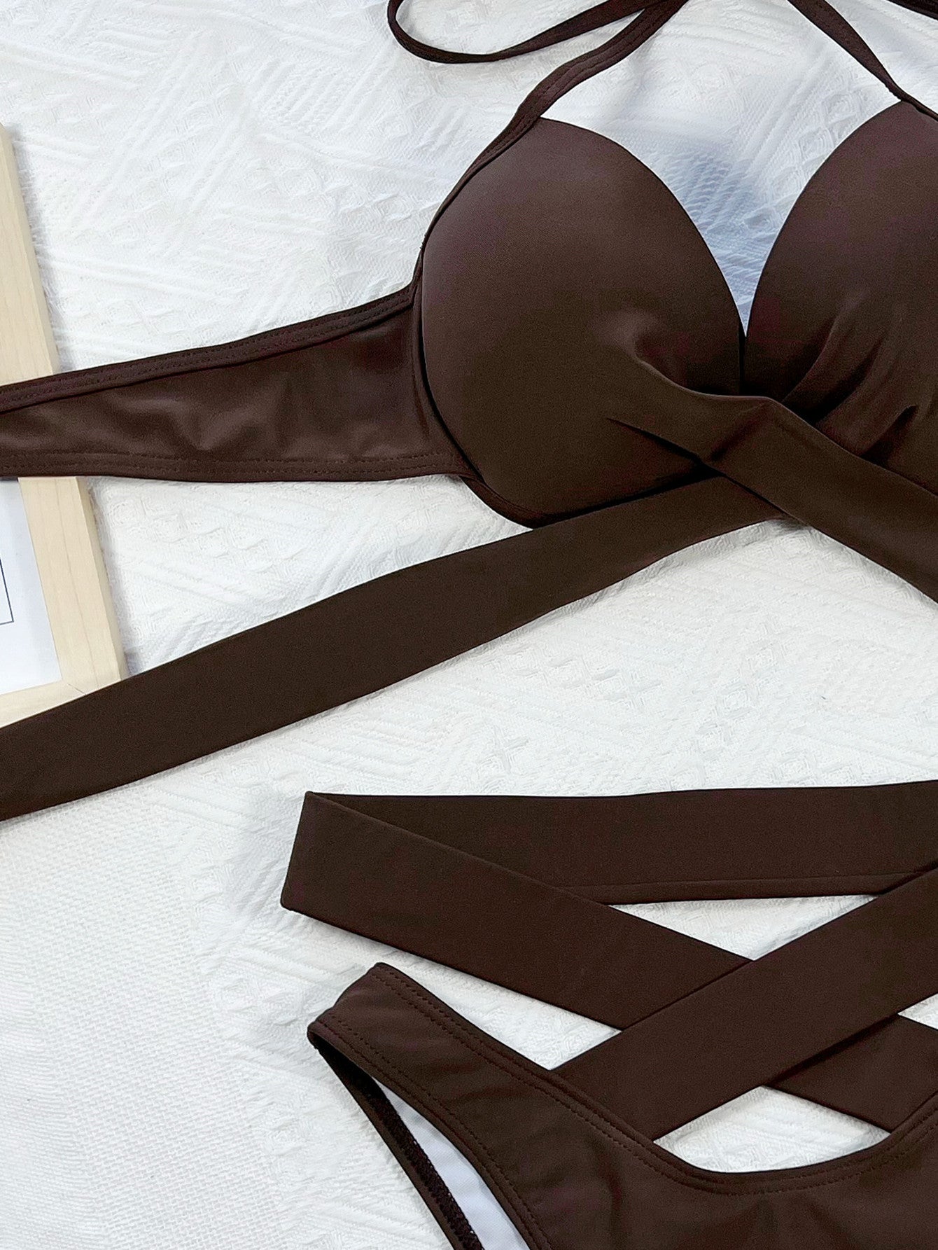 Brown bikini set on a white textured surface
