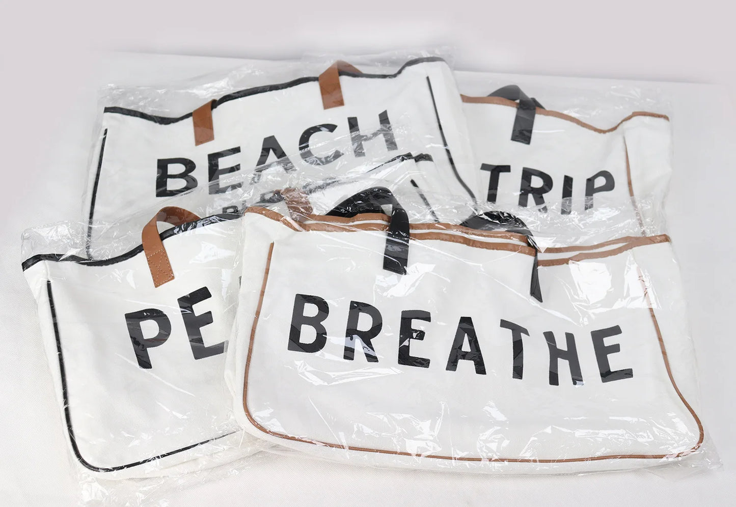 Set of beach bags with text 'BEACH', 'TRIP', 'PEACE', 'BREATHE' on a white background