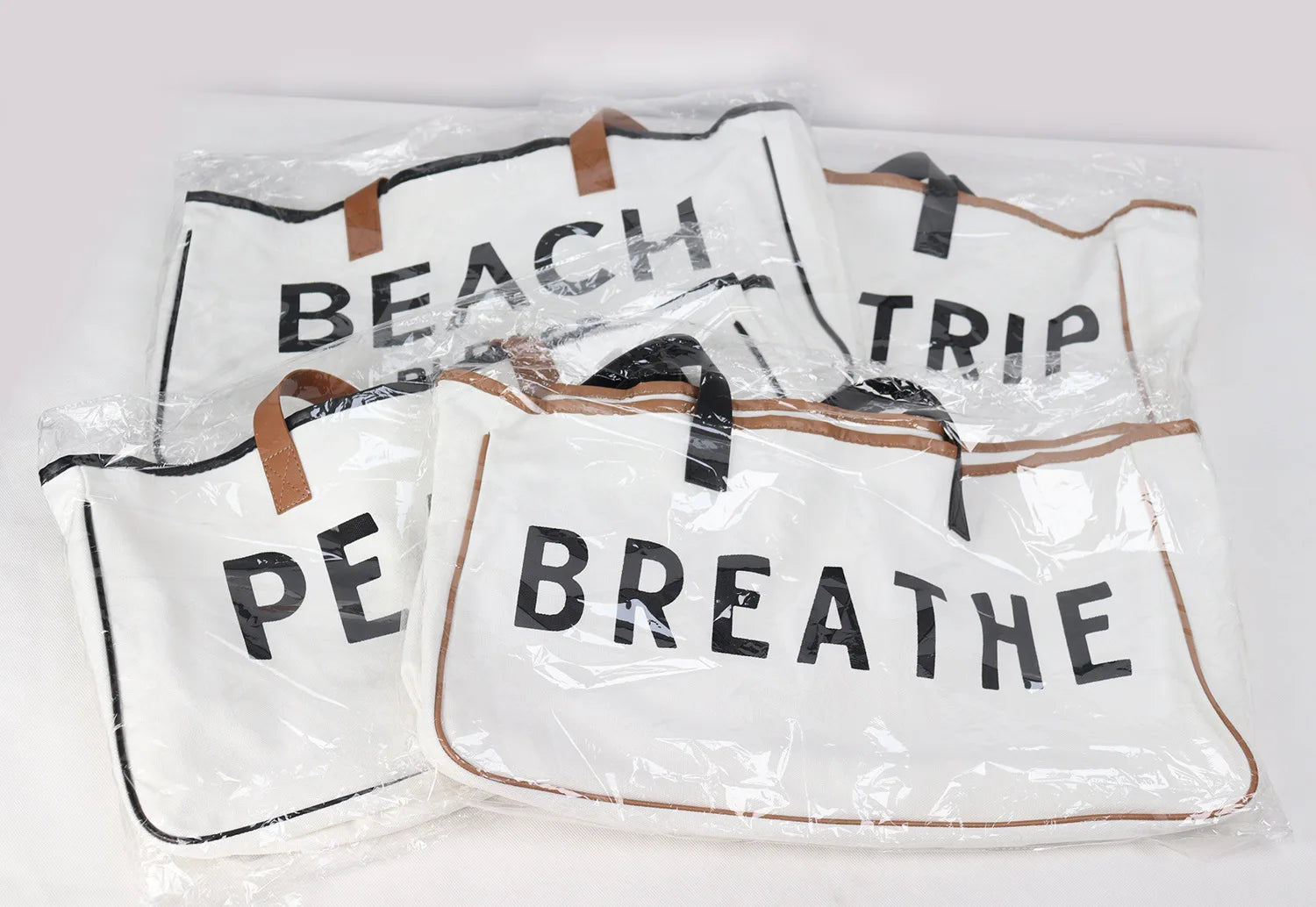 Set of beach bags with text 'BEACH', 'TRIP', 'PEACE', 'BREATHE' on a white background