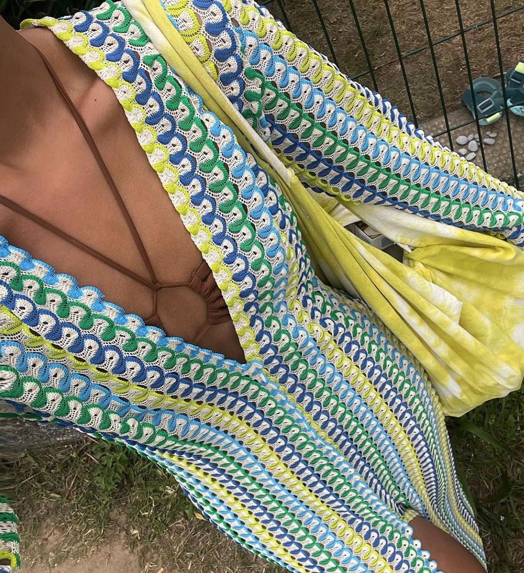 Person sitting in a colorful hammock with a patterned design.
