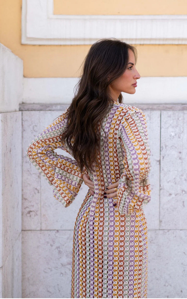 Woman wearing a patterned dress cover-up standing against a classical architecture background