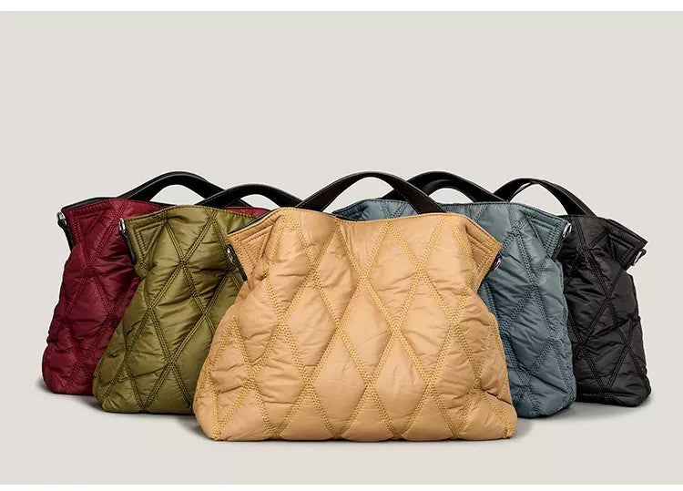 Five quilted handbags in different colors arranged in a row on a light gray background.