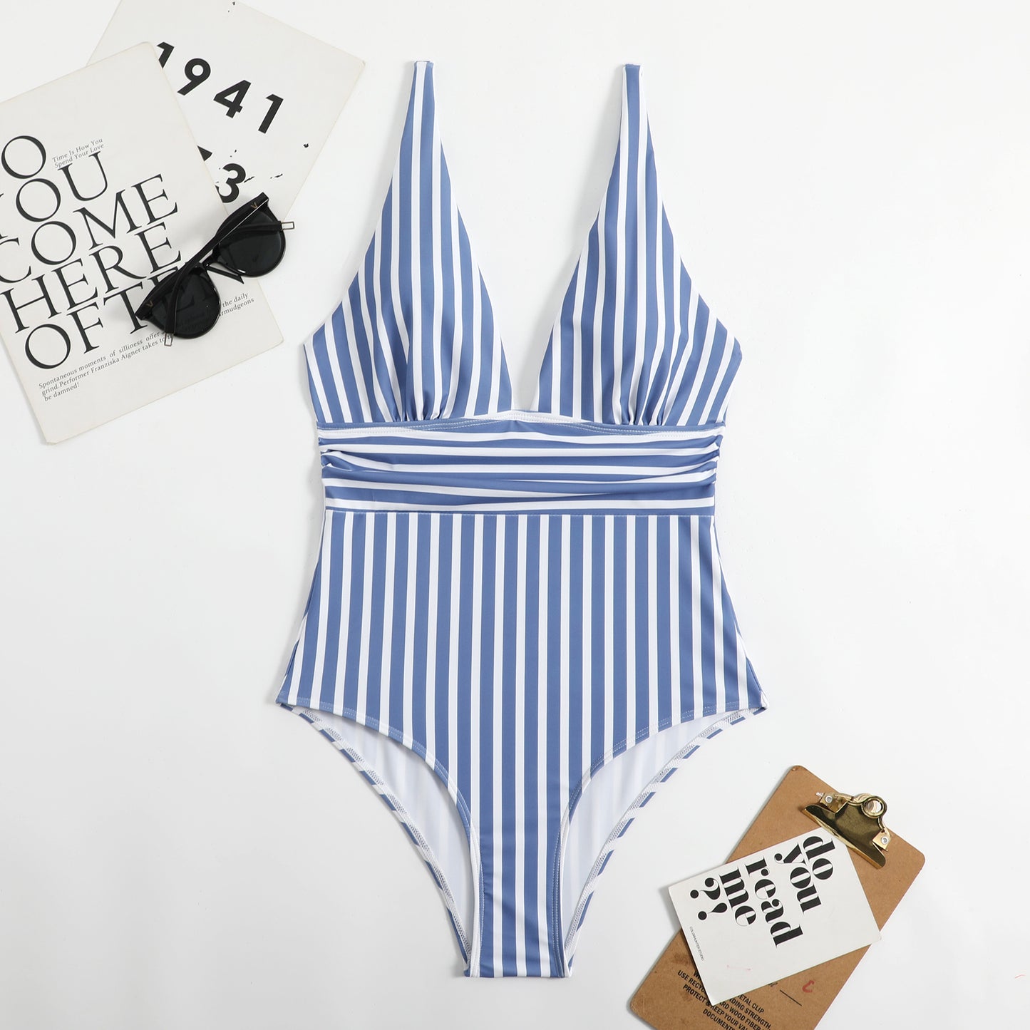 Blue and white striped swimsuit on a light gray background