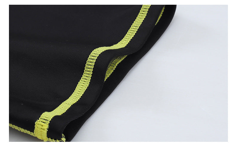 Black fabric with green stitching on a white background